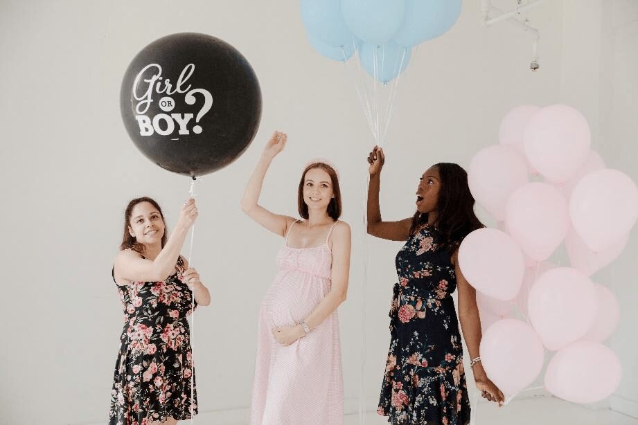 Pregnant Women Holding Balloons At A Gender Reveal Party With Dallas Pregnancy Photographer