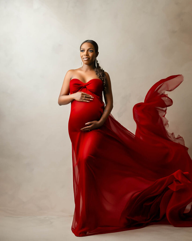Dallas Fine Art Maternity Photography Portrait With Flowing Red Fabric Gown And Dramatic Movement Styling