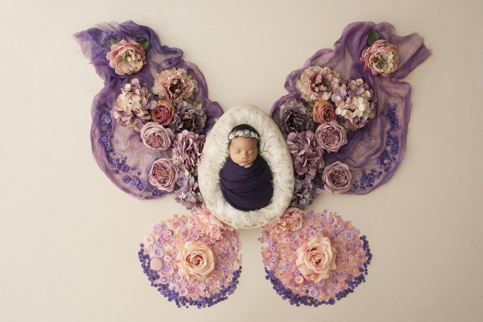 A baby in a purple butterfly shaped frame.