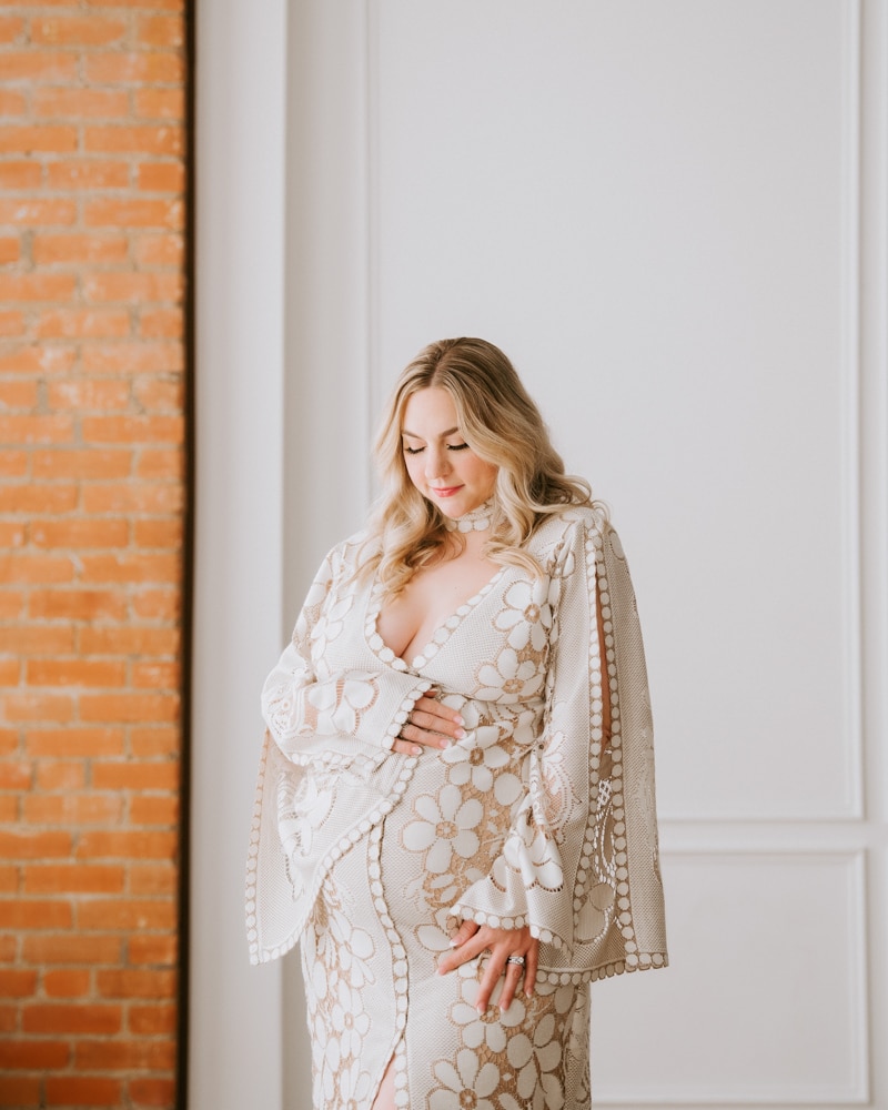 Pregnant Woman Wearing Floral Dress Smiling At Camera For Dallas Maternity Photography