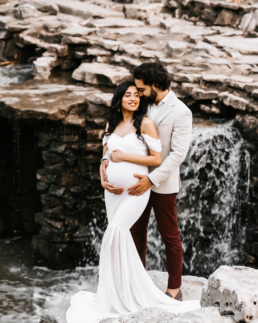 Pregnant Couple Embraced Sweetly Near Waterfall For Dallas Maternity Photographer