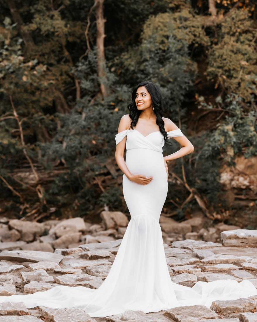 Pregnant Woman Posed On Rocks Smiling At Camera For Dfw Maternity Photographer