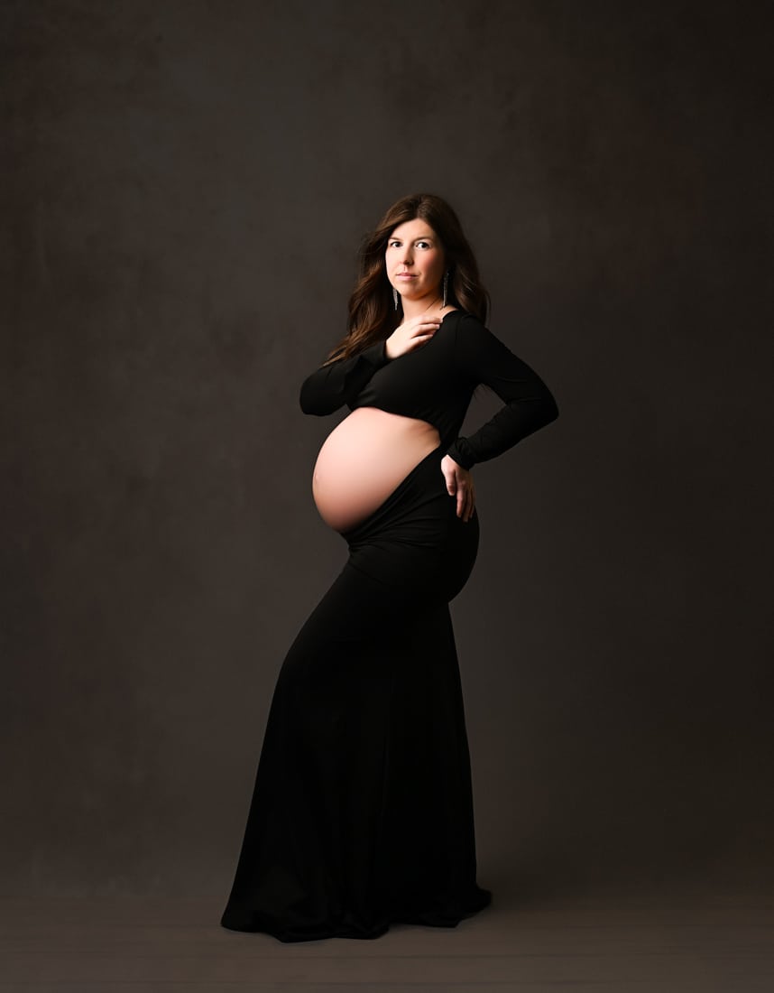 Pregnant Woman In Fitted Black Dress Poses For Maternity Photography Dallas