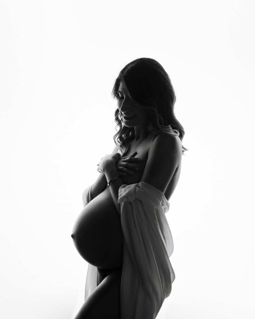 Black And White Silhouette Of A Pregnant Woman Holding Belly For Maternity Photographer Dallas