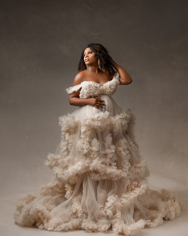 woman posed in an elegant, ruffled gown for dfw maternity photographer