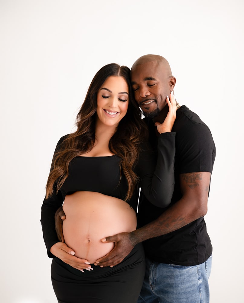 smiling couple poses against a white background for lifestyle maternity photos dallas