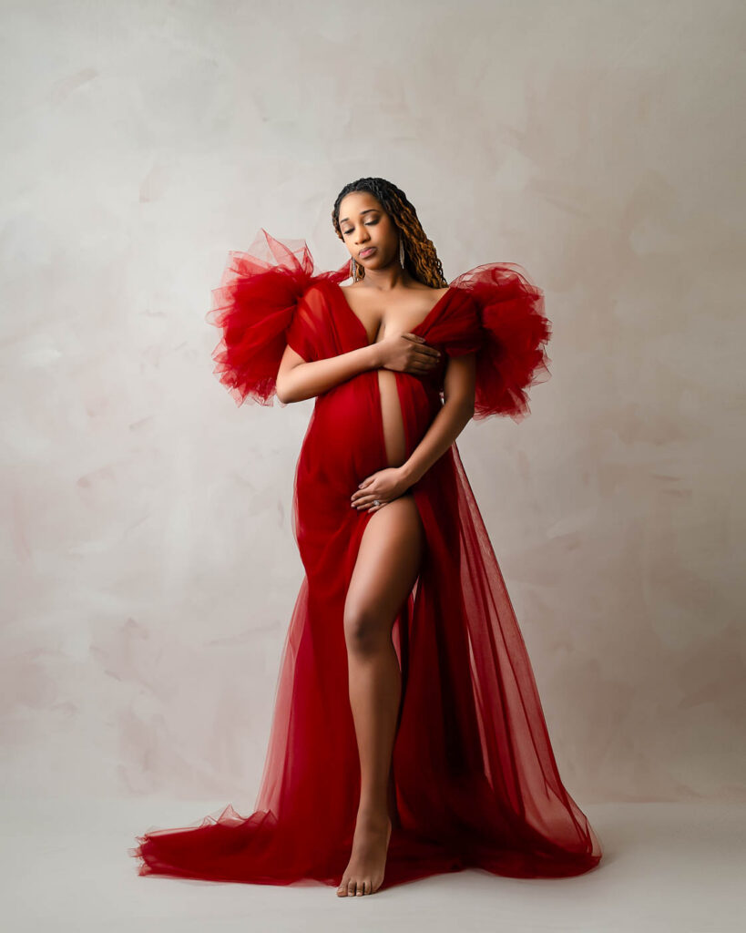 Pregnant Woman Posing In Dramatic Red Couture Gown During Fine Art Maternity Photography Session In Dallas