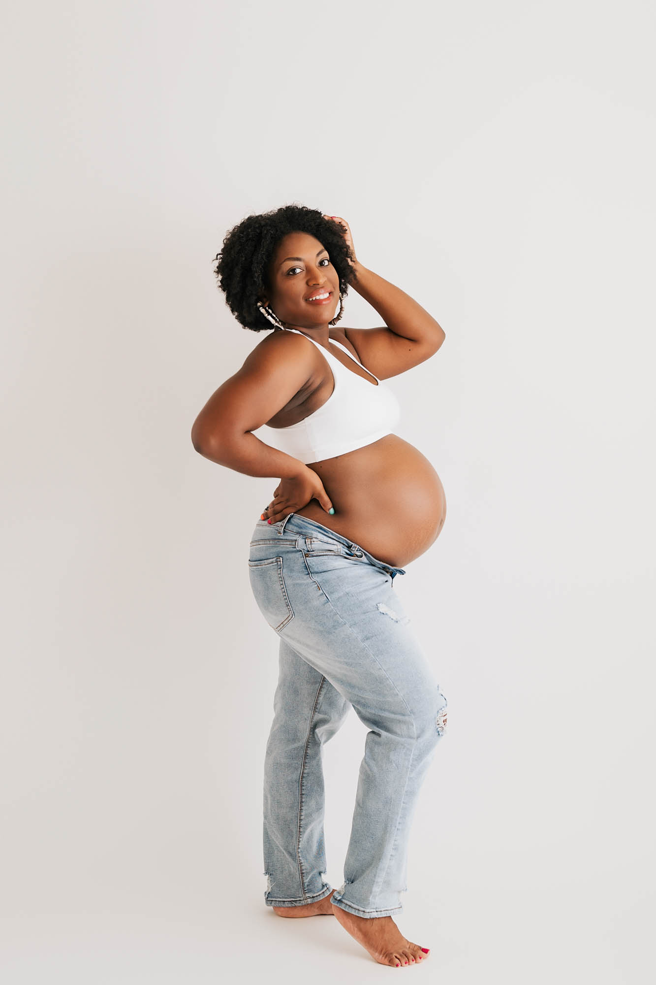 Expecting Mother Posing In Jeans During Maternity Photoshoot In Dallas