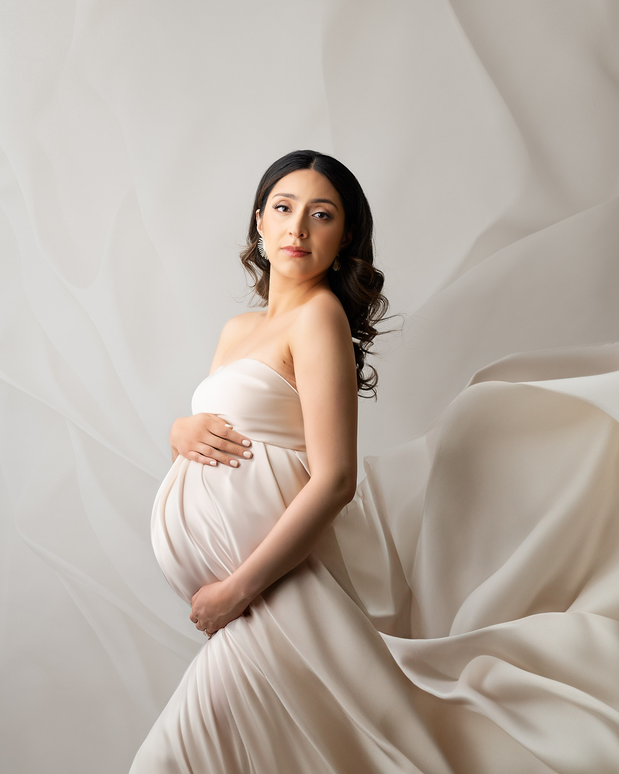 Elegant Maternity Portrait Of A Pregnant Woman In Flowing Cream Dress By Dallas Maternity Photographer