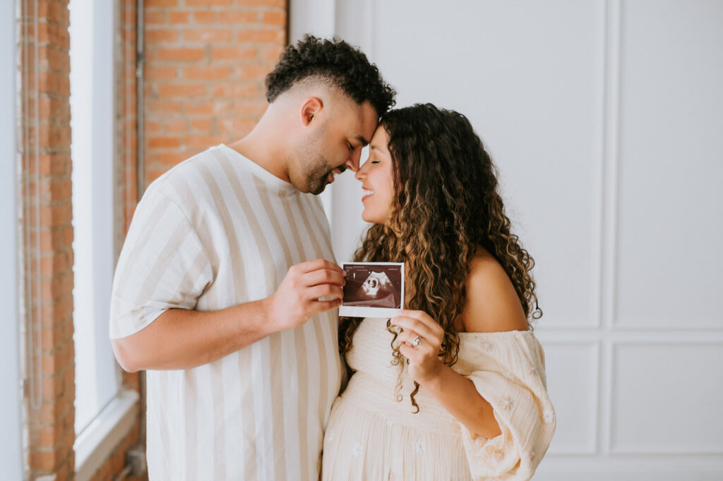 Pregnant Couple Holding Ultrasound Photo During Dallas Maternity Session