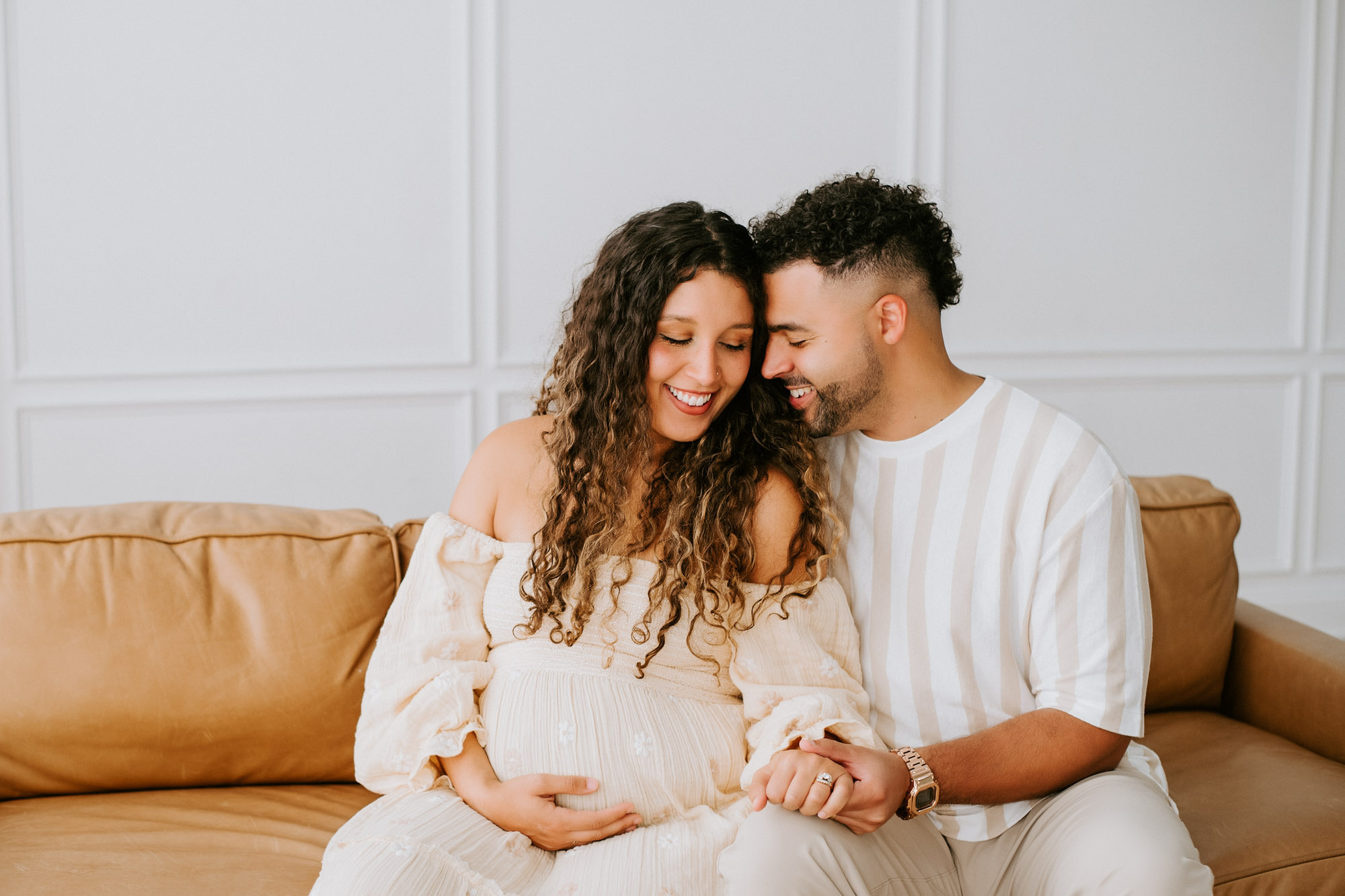 Couple Sitting On Couch Together During Maternity Photography Session In Dallas