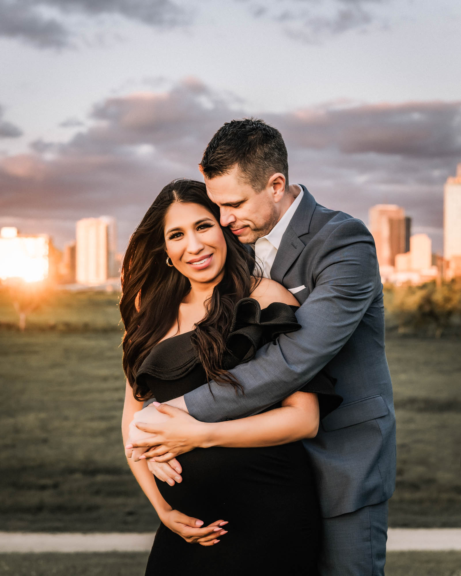 Expecting couple smiling during Dallas maternity photoshoot at golden hour