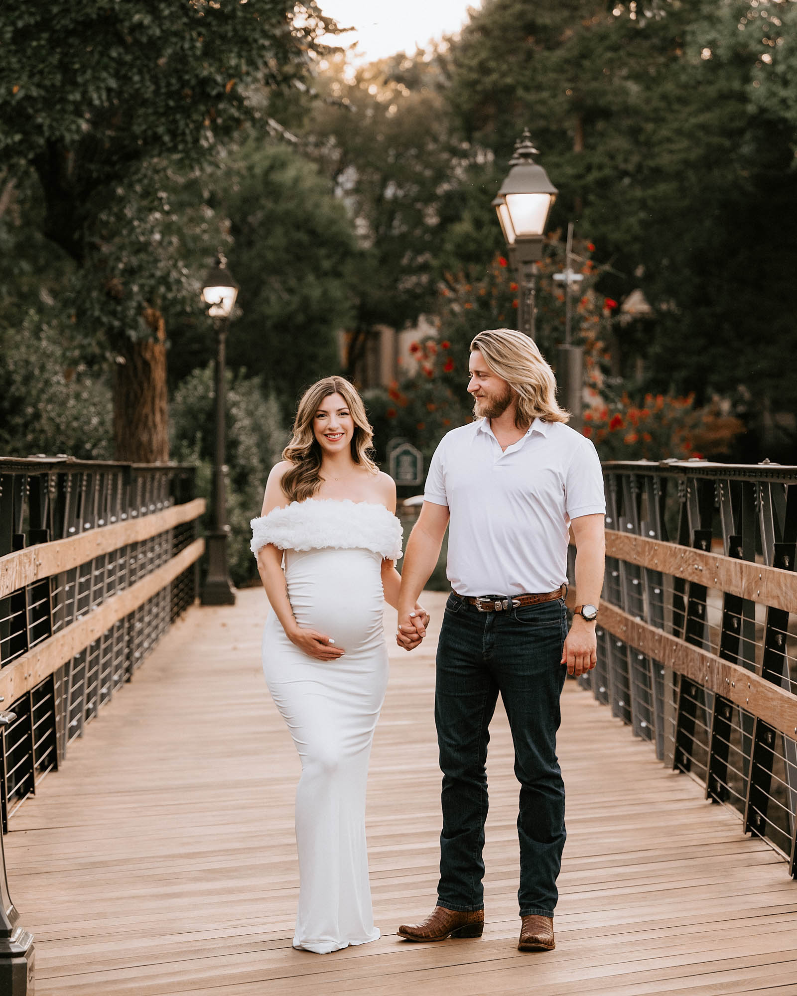 Couple Walking Hand In Hand On Bridge During Dallas Maternity Photoshoot