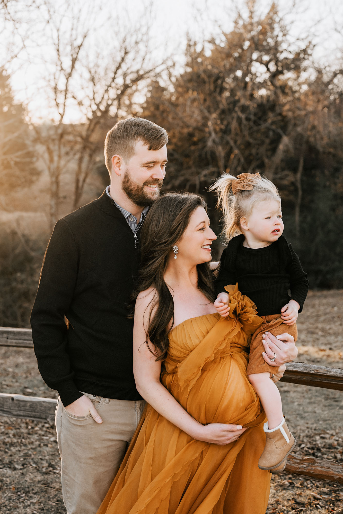 Golden hour maternity family photo in Dallas with pregnant mother, father, and toddler daughter