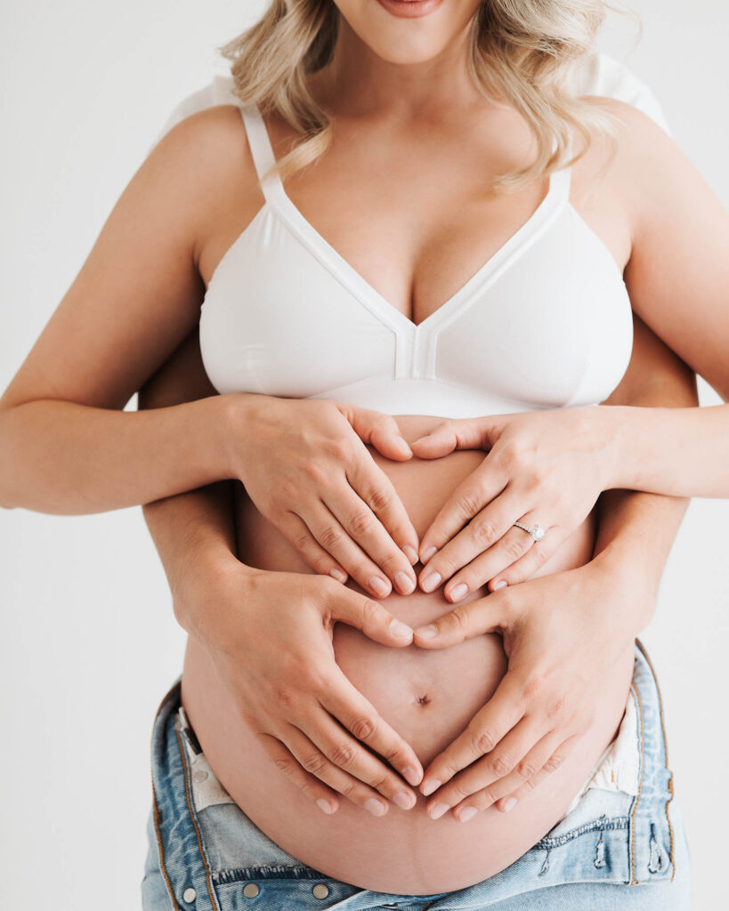 What Happens After Your Maternity Session? From Proofing To Delivery 21 Pregnant Mother Holding Her Belly During A Studio Maternity Session With Partner, Photographed By A Dallas Maternity Photographer At Lily Hayes Photography
