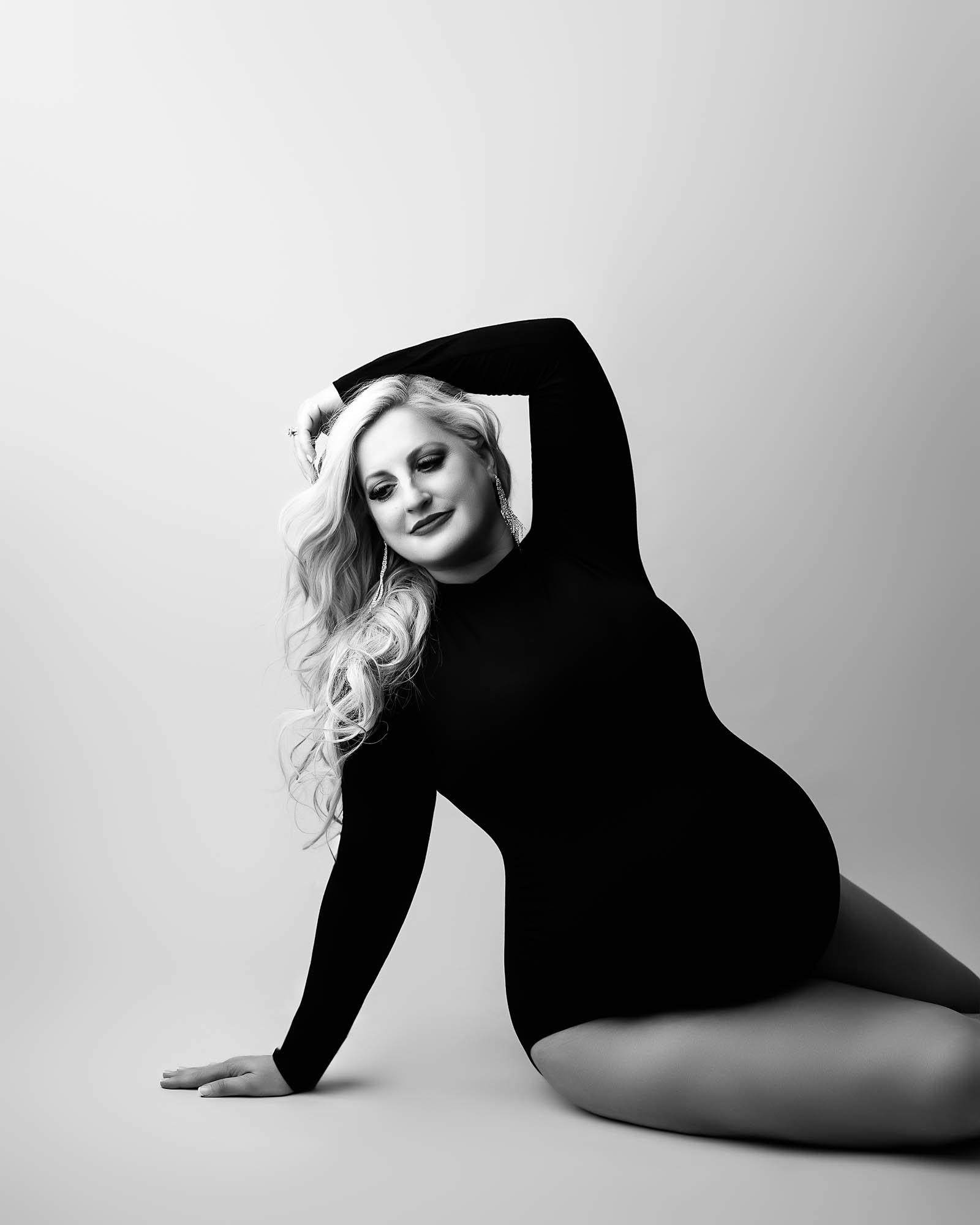 Editorial-style black and white maternity portrait of a pregnant woman posing in studio, photographed in Dallas by Lily Hayes Photography