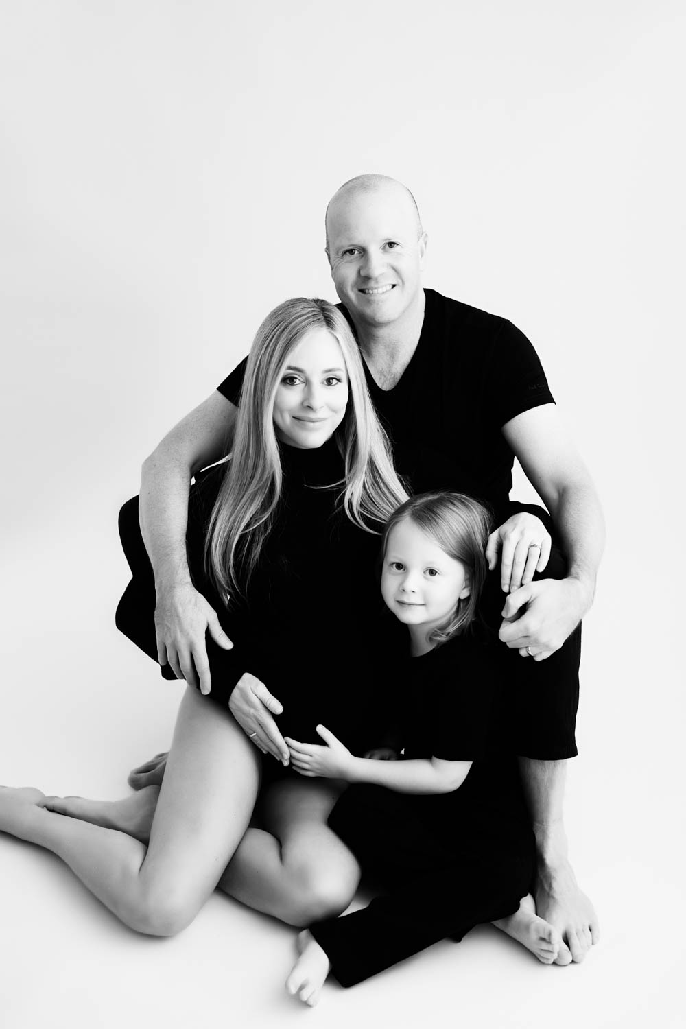 Pregnant woman in flowing brown gown with bow detail, elegant maternity photoshoot in Dallas