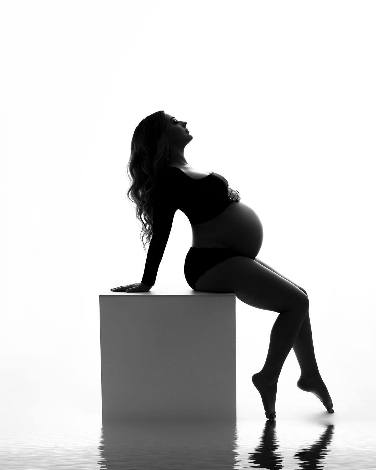 DFW maternity photographer capturing luxury black and white silhouette pregnancy portrait in studio