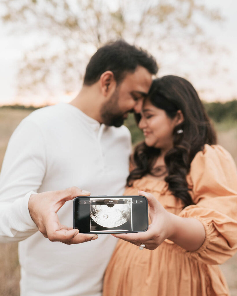 Expecting Couple Holding An Ultrasound Image During A Pregnancy Announcement Maternity Session In Dallas Texas.