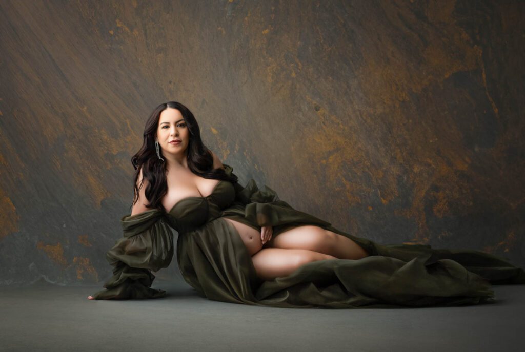 Studio Pregnancy Portrait Of An Expectant Mother Wearing A Flowing Olive Green Gown, Featured Alongside A Client Review For Lily Hayes Photography.