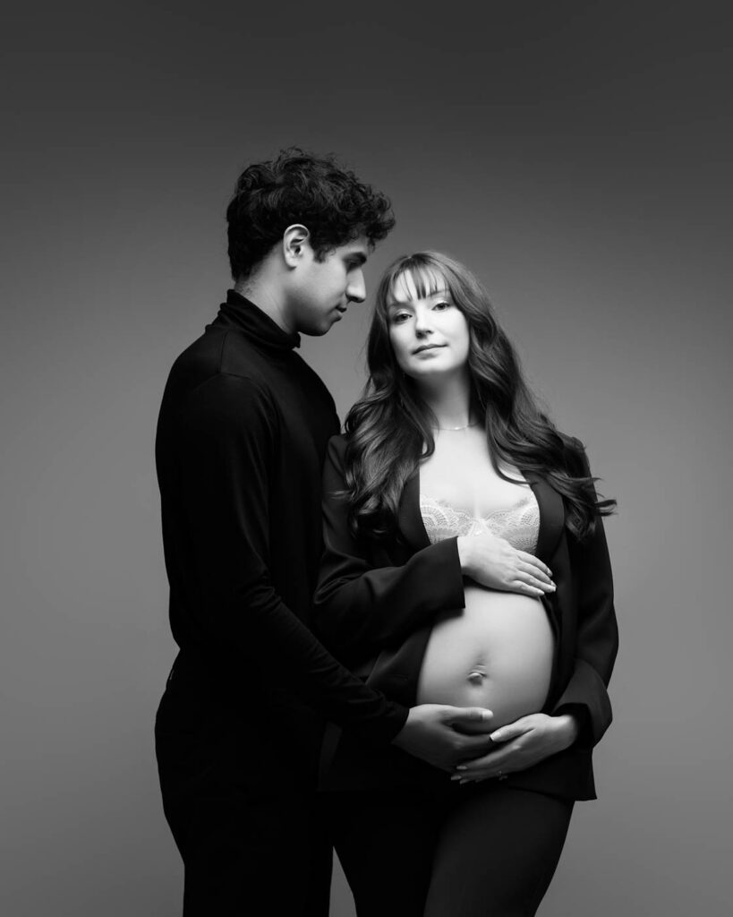 What Happens After Your Maternity Session? From Proofing To Delivery 12 Couple Posing During A Dallas Maternity Photography Session In A Fine Art Studio With The Expectant Father Holding The Mother'S Baby Bump.