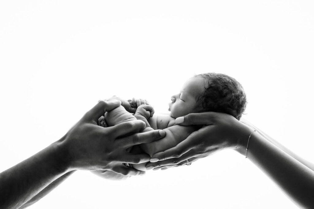 Parents Holding Their Newborn Baby During A Dallas Newborn Photography Session After Their Maternity Portraits With Lily Hayes Photography.