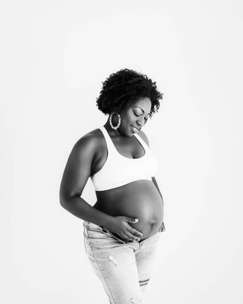 Pregnancy Photographer Dallas Portrait Of An Expecting Mother Standing And Holding Her Baby Bump