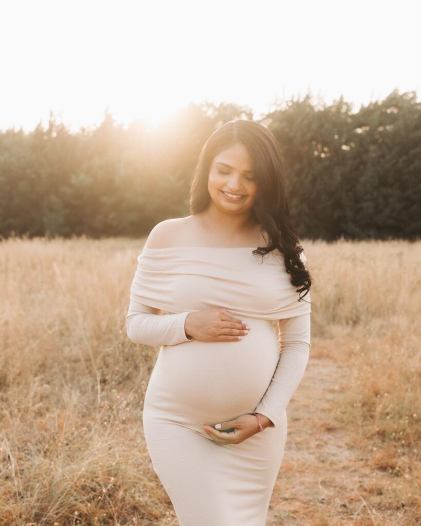 Dallas Maternity Photography Featuring An Expecting Mother In A Neutral Off-The-Shoulder Dress During An Evening Outdoor Session.