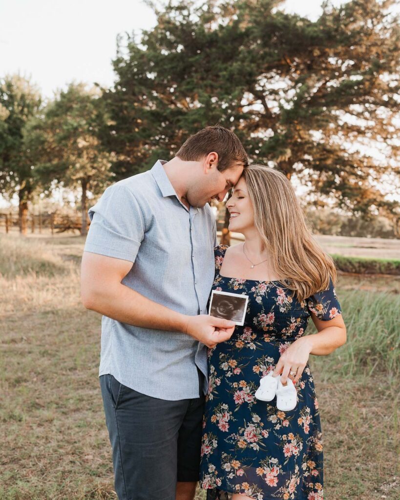Outdoor Maternity Photos For Moms Who Want Something More Relaxed 13 Maternity Photographer In Dallas Capturing Expecting Parents Looking At Their Ultrasound During An Outdoor Pregnancy Session
